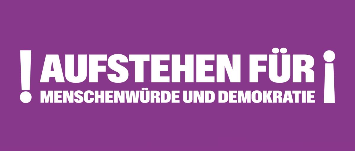 Man sieht in Ausrufezeichen gefassten Schriftzug 'Aufstehen für Menschenwürde und Demokratie!'