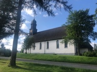 Außenansicht der Kirche vor strahlend blauem Himmel