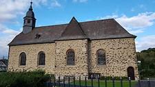 Seitenansicht der Kirche vom Friedhof aus mit kleinem Turm oben links