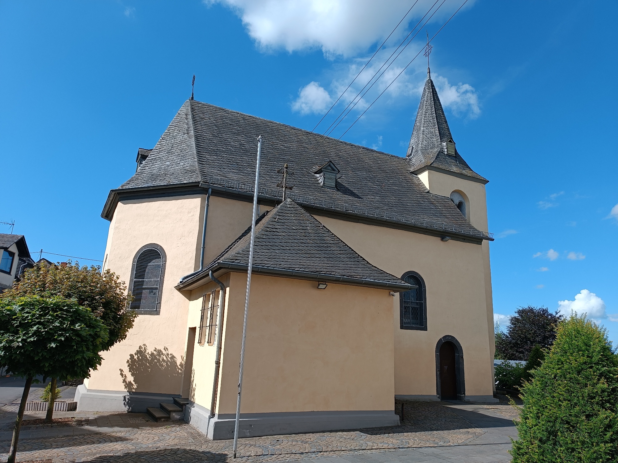 Außenansicht von der Straße aus auf die gelb verputzte Kirche