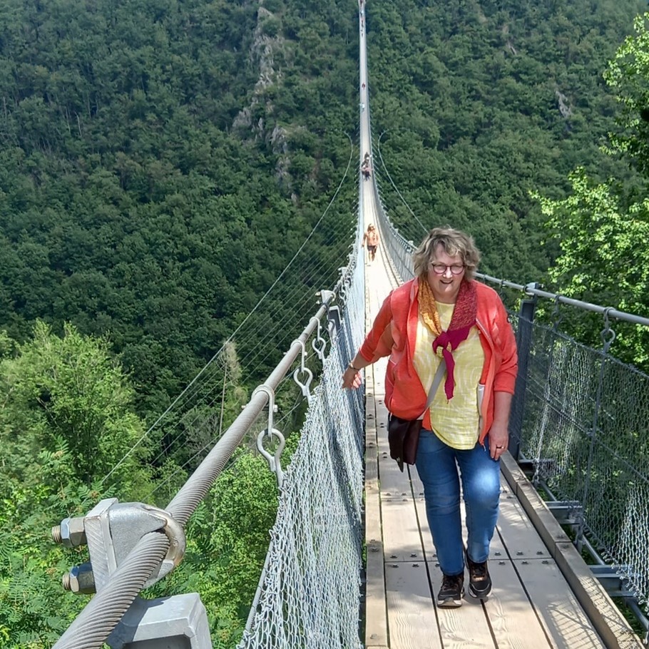 Man sieht eine Frau über eine Hängeseilbrücke gehen