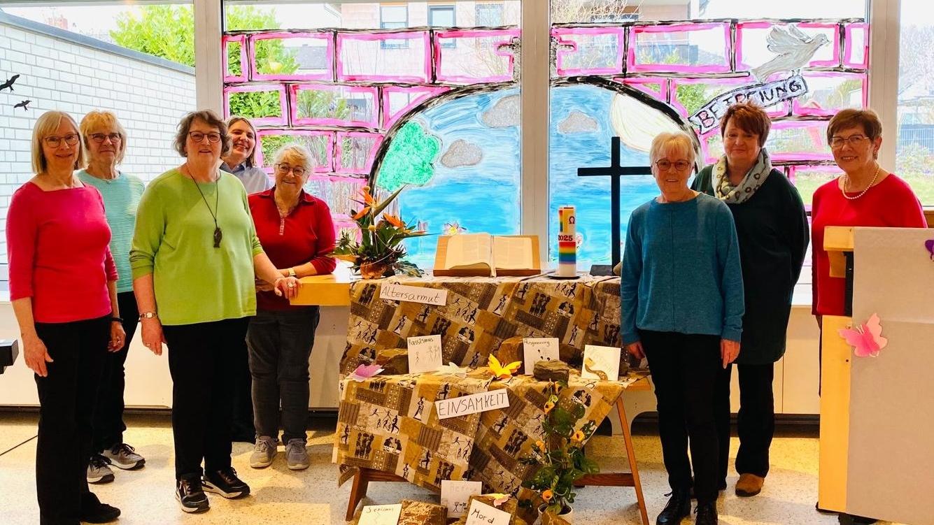 Man sieht in der Mitte einen Altar mit einer afrikanisch anmutenden Decke und Schlagworten geschmückt, mit Buch in der MitteKreuz rechts und
