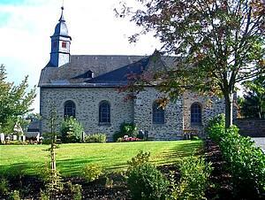 Man bickt auf die Aussenansicht der Kirche seitens des Friedhofs