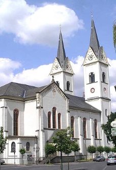 Man sieht den Haupteingang der Kirche in Polch mit Turm rechts und links.